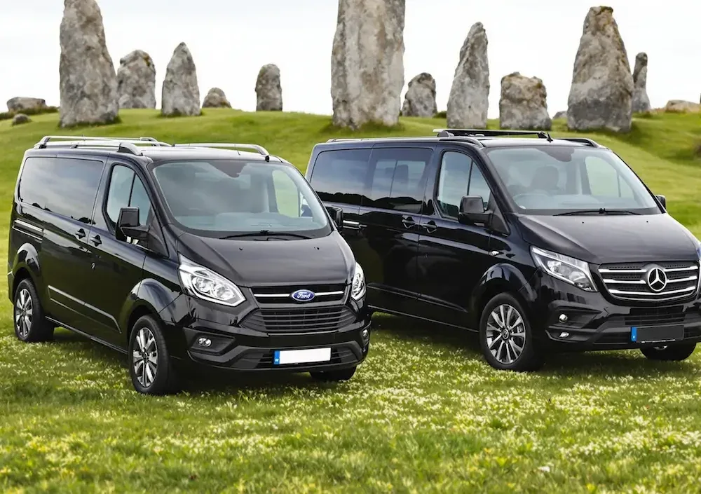 Vans waiting in front of standing stones