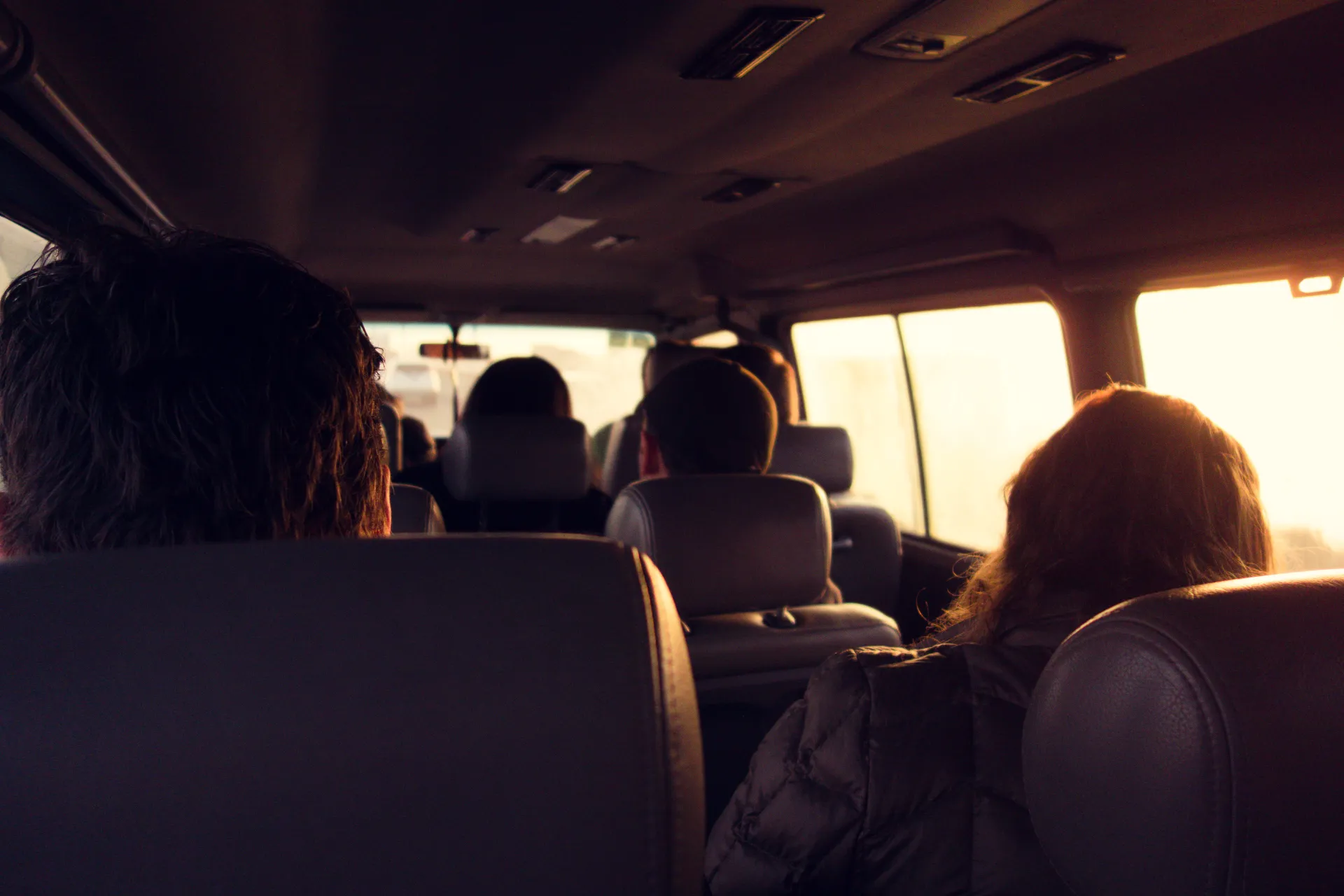 Passagers à bord d'un van, au soleil couchant