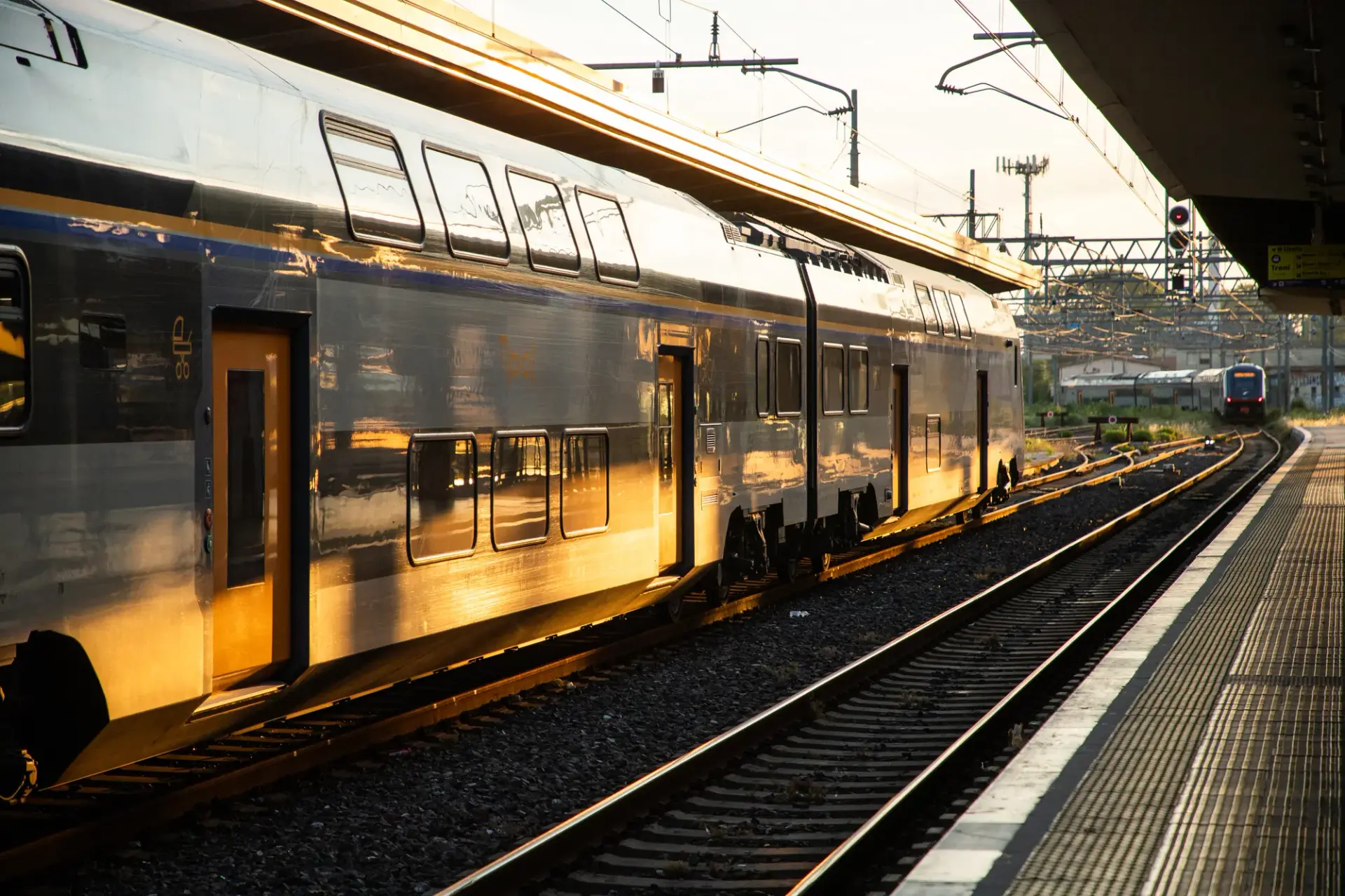 Train à quai dans une gare au soleil couchant